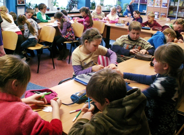 Vaikai spalvino popierines smėlio smilteles